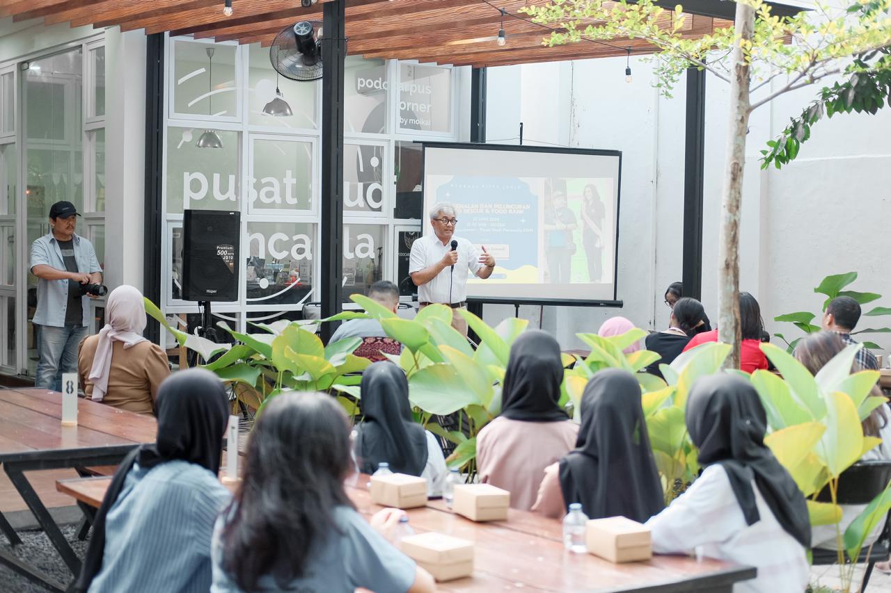 Dosen memberikan pemaparan dalam acara peluncuran komunitas dengan audiens yang antusias.